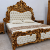 Wooden carving double bed Luxury royal carved bed set with antique gold finish, tufted upholstered headboard, matching side tables, and designer wardrobe for premium bedroom interiors.