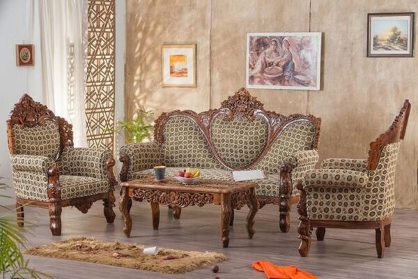 Luxury hand carved wooden sofa set with royal floral upholstery, solid wood frame, matching armchairs, and elegant center table for premium living room interiors.