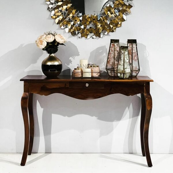 Elegant wooden console table with drawer, curved legs, and decorative items placed on top in a modern home interior setting.
